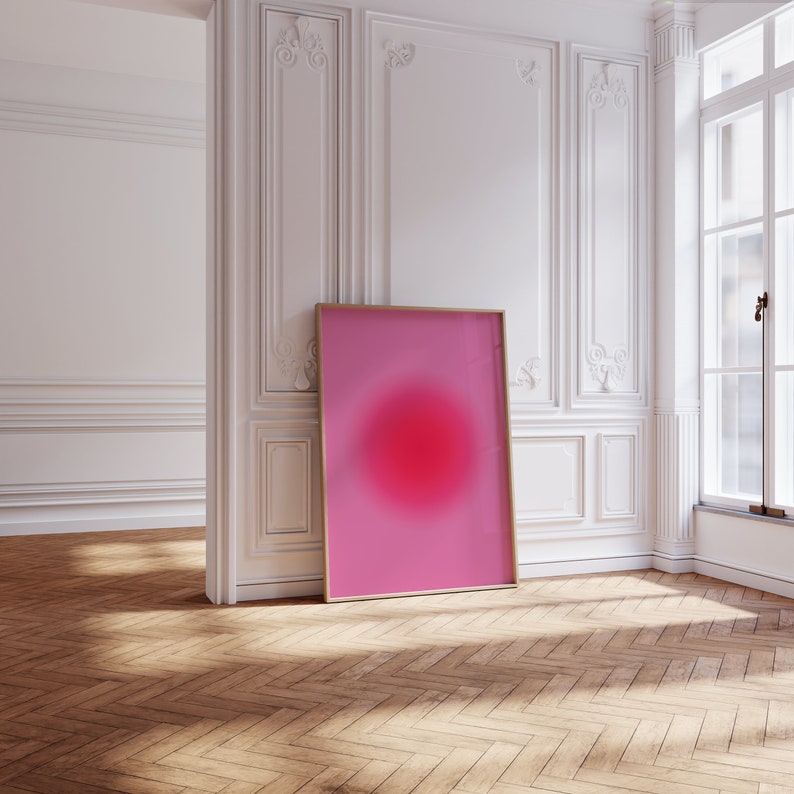 Puede incluir: Una impresi&oacute;n de arte abstracto enmarcada con un fondo degradado rosa y rojo y un gran c&iacute;rculo rojo borroso en el centro.