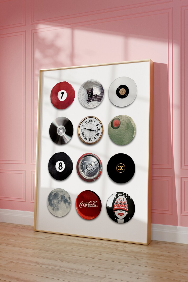 May include: A framed print with a white background featuring 12 round images. The images include a red billiard ball with the number 7, a disco ball, a black and white record, a CD, a clock face, a green circle, a black billiard ball with the number 8, a can of soda, a black circle with the Chanel logo, a moon, a red Coca-Cola can, and a woman's face with a red hat and a red and white patterned design.