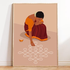 May include: A framed art print shows a woman in traditional Indian clothing, kneeling to draw a white geometric pattern on a light brown surface. She wears an orange blouse and a maroon skirt. A small orange bowl is nearby.