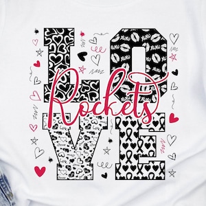 Pode incluir: Camiseta branca com a palavra "LOVE" em um design gráfico. As letras são preenchidas com vários padrões: corações, lábios e fitas. A palavra "Rockets" está escrita em rosa sobre a palavra "LOVE".