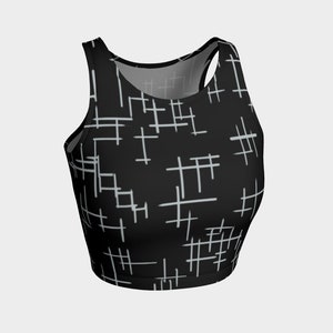 May include: Black crop top with a white geometric pattern. The pattern is made up of thin lines that create a grid-like design.