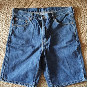 Könnte beinhalten: Eine blaue Jeans-Shorts mit Knopfleiste und fünf Taschen.