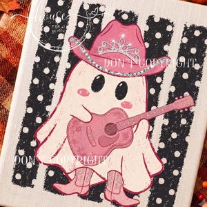 May include: A graphic print on a rectangular surface featuring a white ghost wearing a pink cowboy hat with a silver tiara, pink cowboy boots, and playing a pink acoustic guitar. The background consists of vertical black and white polka dot stripes.
