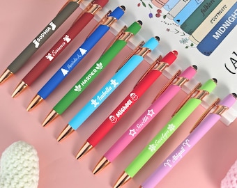 May include: Ten personalized pens with gold accents and a stylus tip. Each pen features a different color and a unique design, including a Christmas stocking, a snowflake, a Christmas tree, and a candy cane. The pens are arranged in a row on a pink surface.