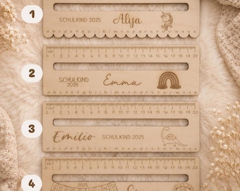 May include: Four rectangular wooden rulers, each 20 cm long, featuring a horizontal slot, a centimetre scale, and the alphabet. Each ruler is engraved with 'SCHULKIND 2025', a unique name (Aliya, Emma, Emilio, Simon), and a graphic: unicorn, rainbow, dinosaur, or lion.