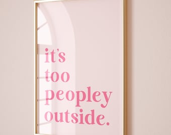 May include: A gold framed print with a pink background and the text "it's too peopley outside." in pink.