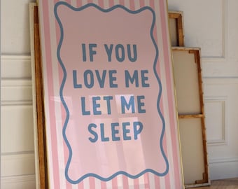 Peut inclure: Une affiche encadrée avec le texte "IF YOU LOVE ME LET ME SLEEP" en lettres bleues sur un fond rose. Le fond présente un motif à rayures roses et blanches. Le cadre est doré.