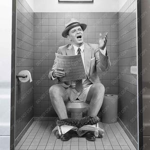 May include: Black and white framed print of a man in a suit and hat sitting on a toilet, holding a newspaper, and singing with his arm raised. The print is in a bathroom setting.