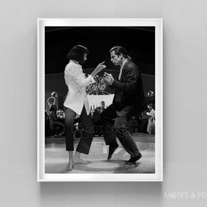 May include: Black and white photograph of a man and woman dancing in a nightclub. The man is wearing a suit and the woman is wearing a white shirt and black trousers.