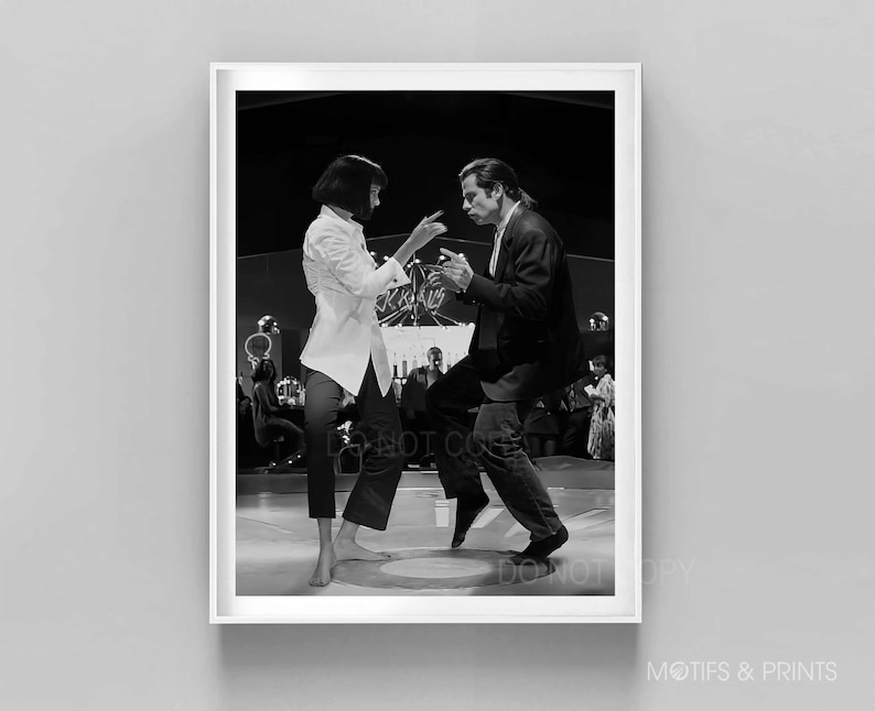 May include: Black and white photograph of a man and woman dancing in a nightclub. The man is wearing a suit and the woman is wearing a white shirt and black trousers.