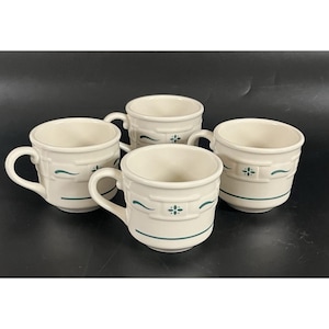 May include: Four off-white ceramic mugs with handles. Each mug features a decorative band with a floral design and a curved line in teal. The mugs are arranged on a dark surface.