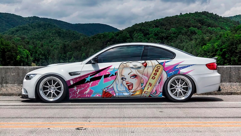 May include: White coupe with custom graphics featuring a cartoon character with blonde pigtails, a baseball bat, and the words "Good Night." The car has custom wheels and is parked on a road with a mountain backdrop.