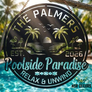 May include: A black metal sign with the words "THE PALMERS" and "Poolside Paradise" in a circular design. The sign features palm trees, flamingos, and the text "RELAX & UNWIND". The sign is hanging from a chain.