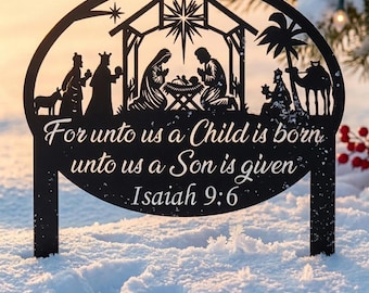 May include: A black metal yard sign featuring a nativity scene silhouette with a star, stable, and figures. The text reads: For unto us a Child is born, unto us a Son is given, Isaiah 9:6. The sign has two stakes for ground insertion.