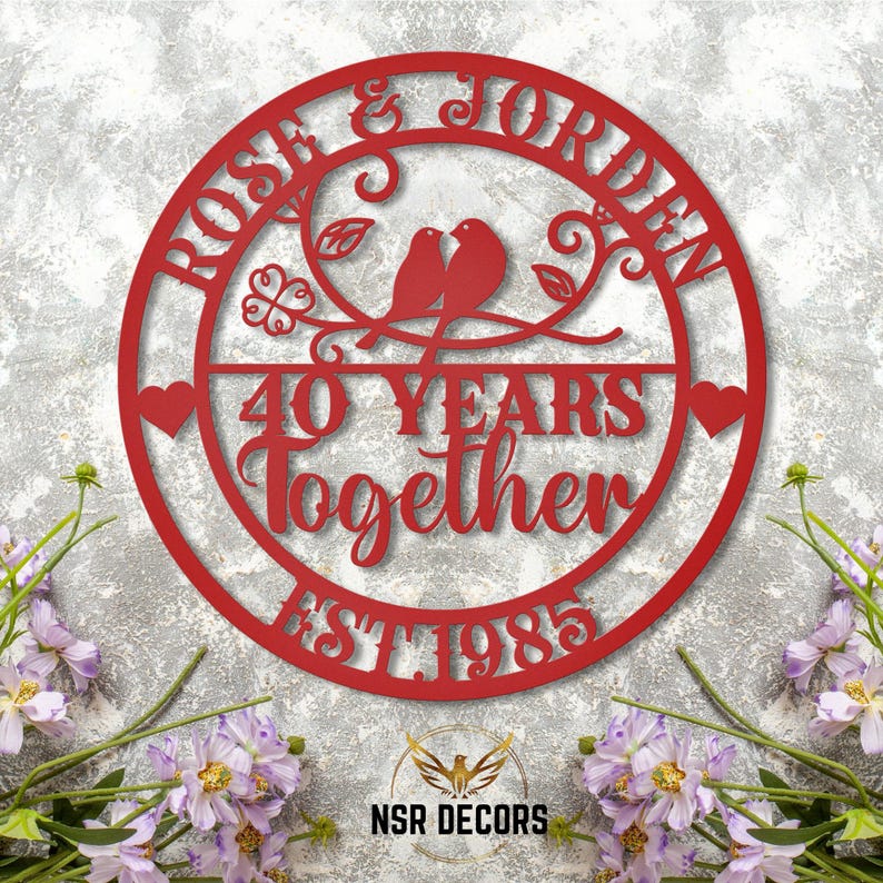 Puede incluir: Un letrero de metal rojo con el texto "Rose & Jordan 40 Years Together Est 1985" y dos p&aacute;jaros en una rama con hojas.