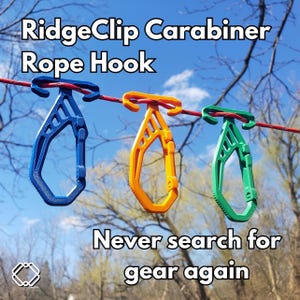 Puede incluir: Tres ganchos de cuerda de plástico de colores colgados de una cuerda para tender la ropa. Los ganchos son azules, amarillos y verdes. El texto "RidgeClip Carabiner Rope Hook" está en la parte superior de la imagen. El texto "Nunca más busques equipo" está en la parte inferior de la imagen.