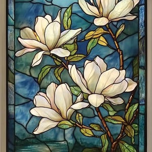 Può includere: Pannello in vetro colorato con fiori di magnolia bianchi su sfondo blu e verde acqua. I fiori hanno petali dettagliati, foglie verdi e steli marroni. Il pannello è incorniciato da un bordo bianco.