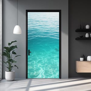 Puede incluir: Una puerta con marco negro que presenta una imagen vibrante de agua turquesa clara. La superficie del agua refleja la luz solar, creando un efecto brillante. La puerta está situada en un interior moderno con una planta en maceta blanca y una lámpara colgante.
