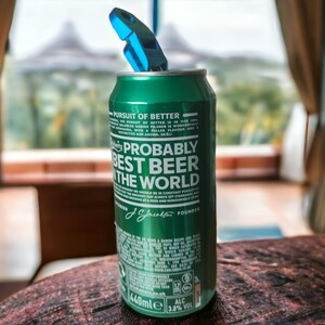 May include: A green aluminum can of beer with the text "Probably the best beer in the world" and the brand name "J.J. Smith's" printed on it. The can is partially open with a blue can opener on top.