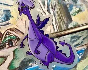 Può includere: Un adesivo di drago viola con un'espressione scontrosa, capelli bianchi e ali nere. Il drago cammina su un fiume blu con un'area verde erbosa e una piccola casa marrone sullo sfondo.