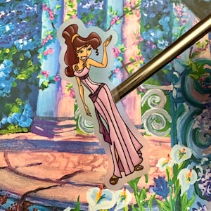 May include: A sticker featuring a cartoon illustration of a woman with brown hair and a purple dress. She is waving with her right hand and smiling. The background is a watercolor painting of a garden with flowers.
