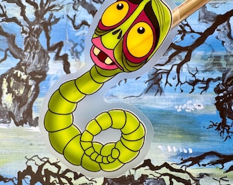 May include: A green worm with a human-like face, large yellow eyes, and a pink mouth. The worm is curled up in a circle and has a surprised expression.