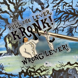 Puede incluir: Una pegatina transparente con una imagen de dibujos animados en blanco y negro de dos personajes. El texto en la pegatina dice "Pull the Lever, Kronk! Wrong Lever!"