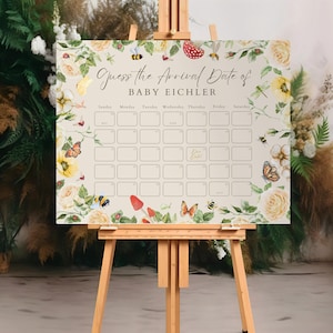 May include: A cream-coloured baby shower game board on an easel, with the text "Guess the Arrival Date of BABY EICHLER." The board is decorated with watercolour flowers, butterflies, bees, and mushrooms. It has a calendar grid for guests to write their guesses.