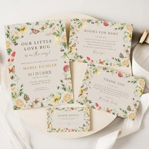 May include: A set of baby shower invitations and cards with a floral and insect theme. The main invitation reads "Our Little Love Bug is on the way!" with details for Mabel Eichler's baby shower. Other cards include "Books for Baby," "Thank You," and a diaper raffle card.