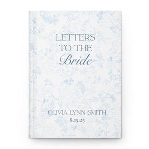 May include: A hardcover book titled "Letters to the Bride" with a floral pattern in light blue on a white background. The bride's name and date are printed at the bottom. The book is a keepsake for a wedding.