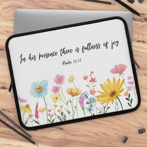May include: White laptop sleeve with a floral design and the quote "In his presence there is fullness of joy - Psalm 16:11".