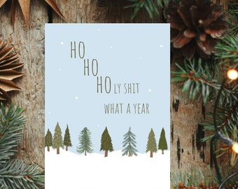 May include: A blue Christmas card with a snowy forest scene and the text "HO HO HO LY SHIT WHAT A YEAR".