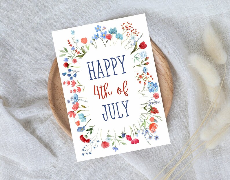May include: A white card with a blue and red floral border. The text "HAPPY 4th of JULY" is written in the center of the card.