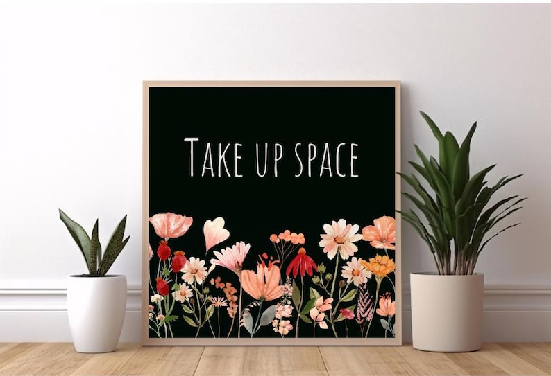 May include: A black and white print with the text "Take Up Space" in white lettering. The print features a border of watercolor flowers in shades of pink, red, and orange.