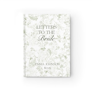 May include: A hardcover journal with a floral design in shades of green and white. The cover reads "LETTERS TO THE Bride" with the name "EMMA JOHNSON" and the date "8.7.25" printed below. The journal is a wedding keepsake.