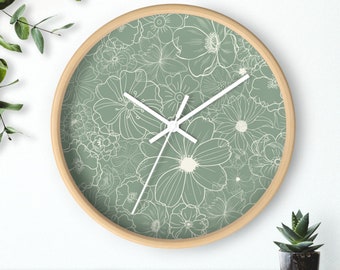 May include: A round, wooden-framed clock with white hands and a green face. The face is covered in a pattern of white flowers.