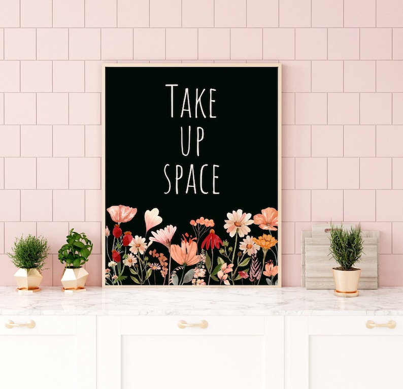 May include: Black and white print with the text "Take Up Space" surrounded by a border of colorful watercolor flowers.