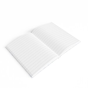 May include: An open notebook with lined pages. The notebook is white with a subtle pattern on the cover.
