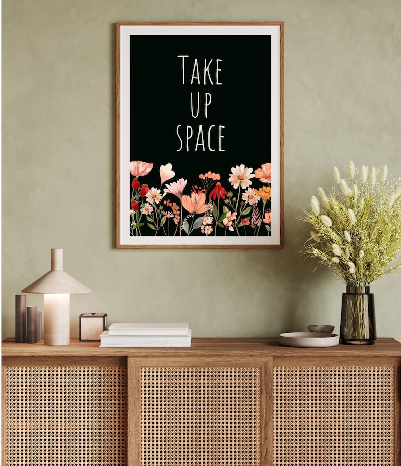 May include: A black and white print with the text "TAKE UP SPACE" in white lettering. The print features a border of colorful flowers on a black background.