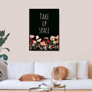 May include: Black and white print with the text "TAKE UP SPACE" in white lettering. The print features a row of colorful flowers at the bottom.