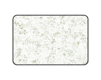 May include: Rectangular mouse mat with a detailed floral design in green and white. The pattern features botanical illustrations of leaves and flowers on a white background. The mouse mat has a black border.