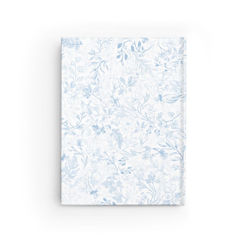 May include: A blue and white floral pattern on a notebook cover. The pattern is a delicate design of leaves and flowers.