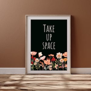 May include: Black and white print with the text "TAKE UP SPACE" in white font. The print features a border of watercolor flowers in shades of pink, red, and yellow.