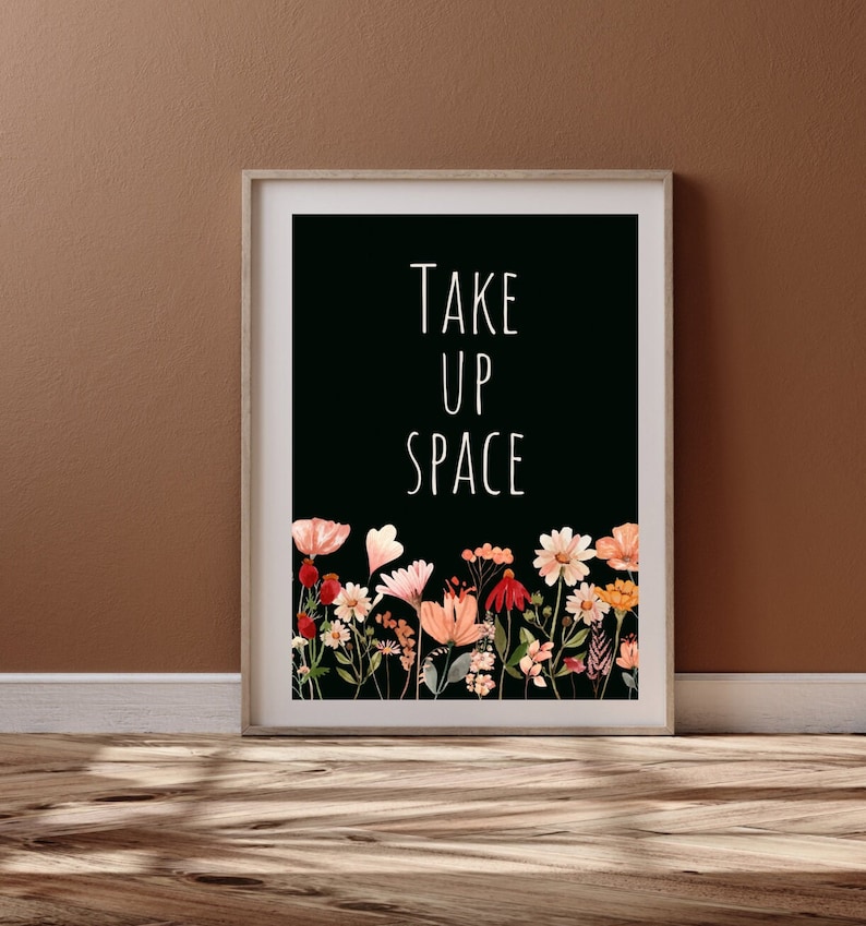 May include: Black and white print with the text "TAKE UP SPACE" in white font. The print features a border of watercolor flowers in shades of pink, red, and yellow.