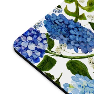 K&ouml;nnte beinhalten: Ein wei&szlig;er Hintergrund mit einem sich wiederholenden Muster aus blauen Hortensienbl&uuml;ten und gr&uuml;nen Bl&auml;ttern. Die Blumen sind in Aquarelltechnik gemalt.