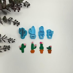 May include: Set of seven blue plastic cactus cookie cutters and six green plastic cactus cookie cutters with pink flowers.