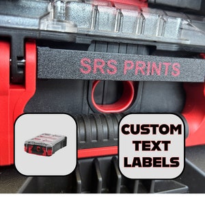 Può includere: Una cassetta degli attrezzi rossa e nera con un'etichetta nera che dice "SRS PRINTS CUSTOM TEXT LABELS". L'etichetta è sulla maniglia della cassetta degli attrezzi. C'è una piccola cassetta degli attrezzi rossa e nera all'interno della cassetta degli attrezzi più grande.