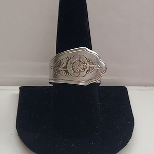 Könnte beinhalten: Ein silberner Ring aus einer wiederverwendeten Löffel mit einem Rosenmuster.