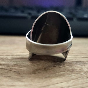 K&ouml;nnte beinhalten: Ein silberner Ring mit abgerundeter, gew&ouml;lbter Oberseite. Der Ring besteht aus zwei miteinander verbundenen Metallteilen.