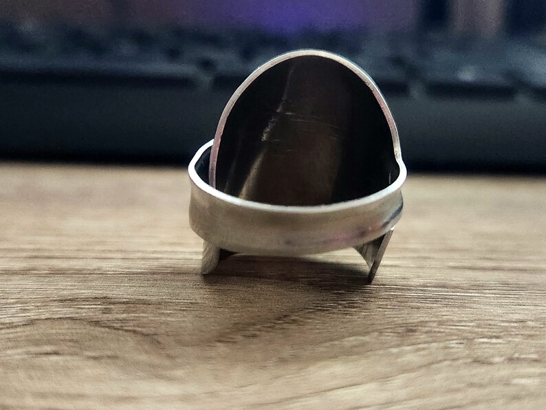 K&ouml;nnte beinhalten: Ein silberner Ring mit abgerundeter, gew&ouml;lbter Oberseite. Der Ring besteht aus zwei miteinander verbundenen Metallteilen.
